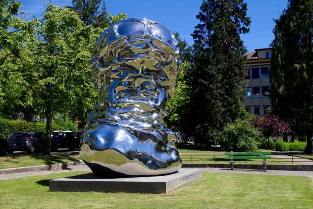 Il busto in acciaio di Louis Chevrolet luccica al sole.