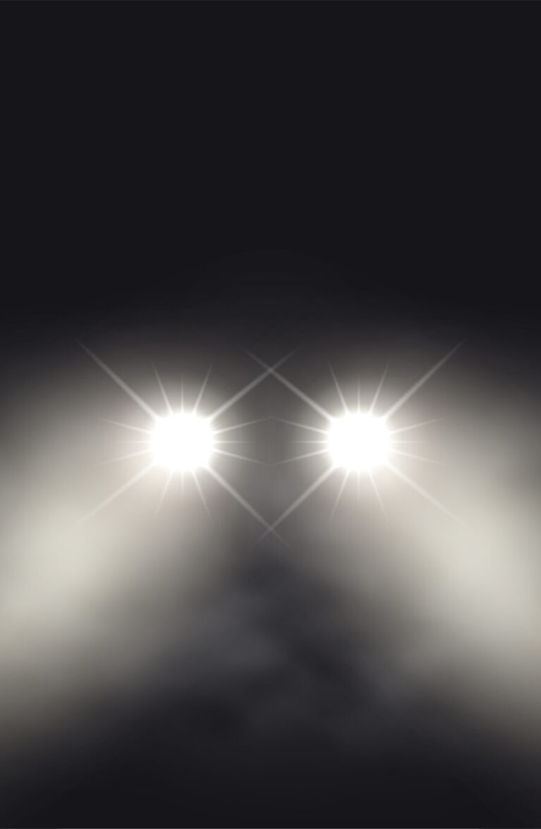 Leuchtende Autolichter im Nebel bei Nacht