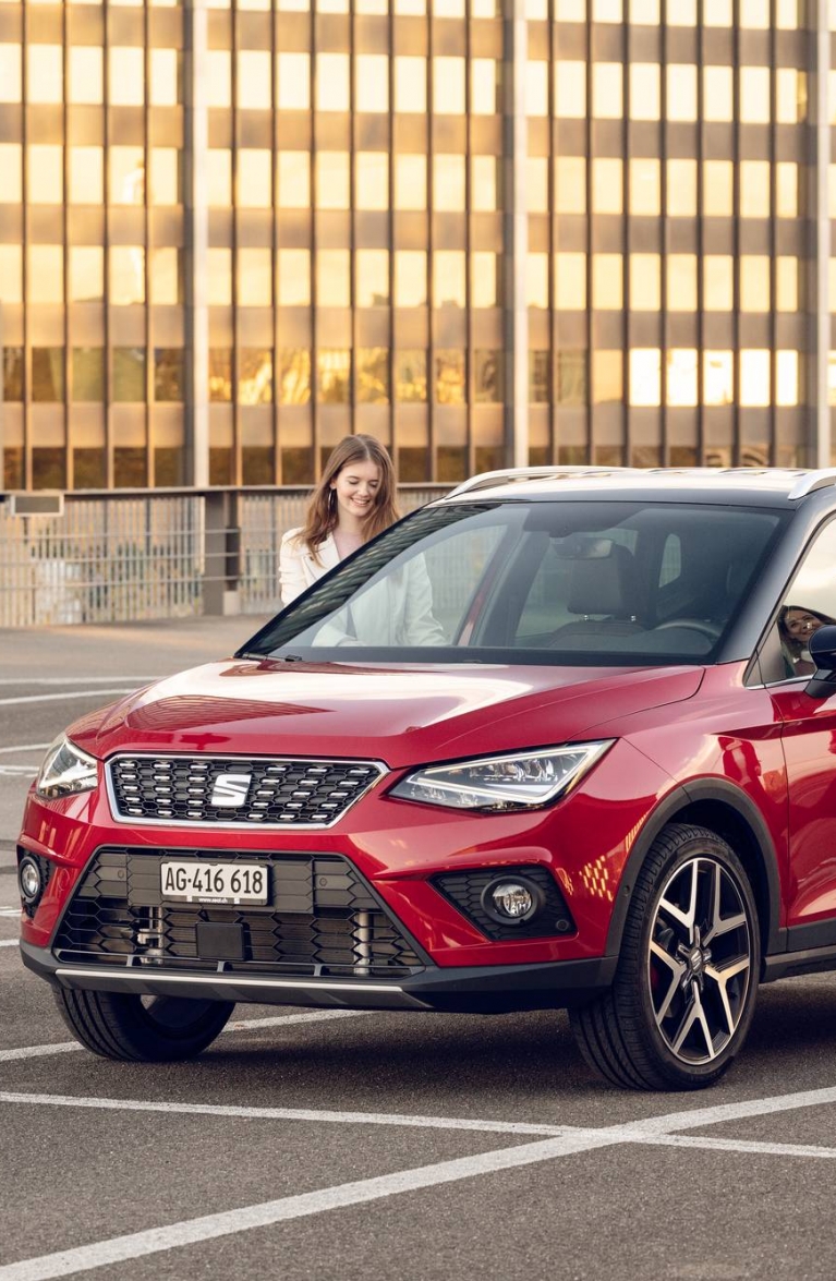 Zwei Frauen auf einem Parkfeld, die in ein Auto einsteigen. Sinnbildlich für Mobility Solutions.