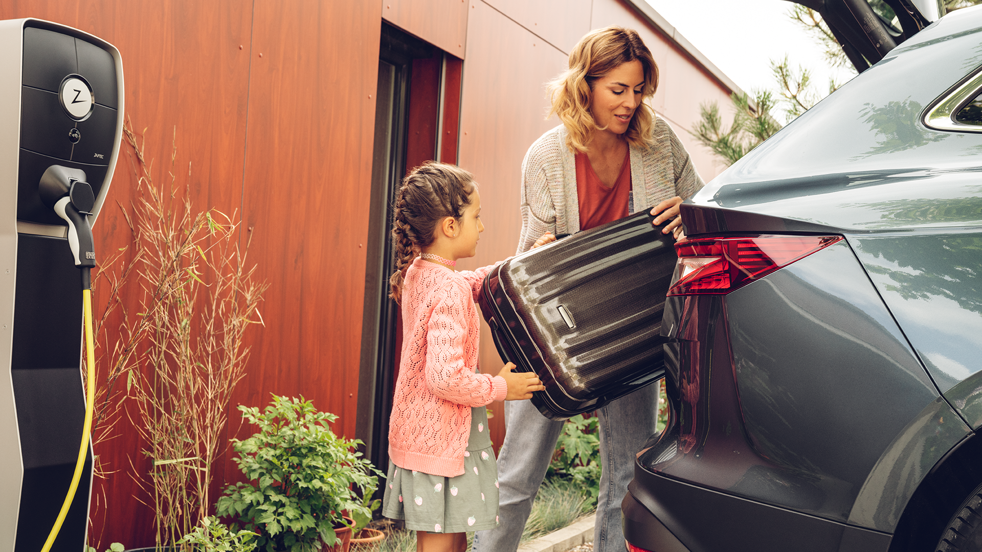 Auto elettrica Caricare la valigia nel bagagliaio Madre e figlio